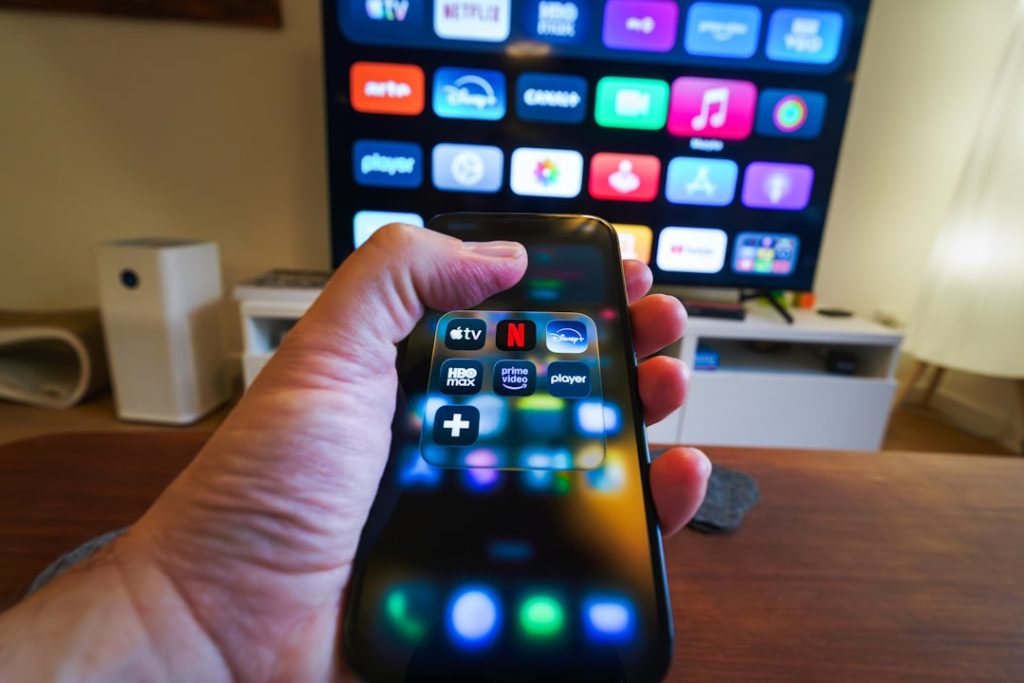 Hand pointing remote at TV running xciptv player setup guide