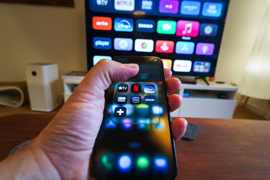 Hand pointing remote at TV running xciptv player setup guide